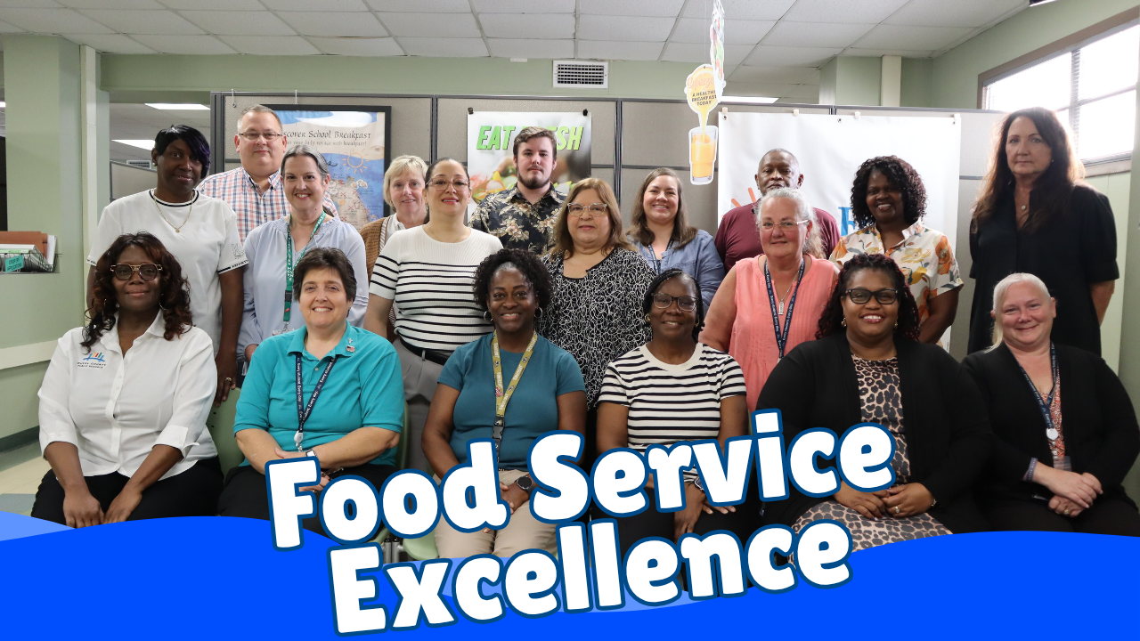 Group of adults in a room with a banner that reads "Food Service Excellence" below them.