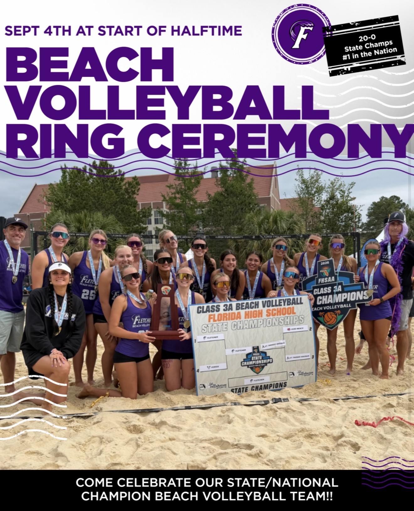 Group of volleyball players posing with medals and a large sign on the beach. Buildings in the background.