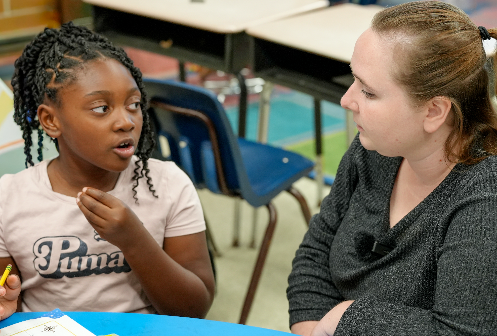 Jessica Mauch, a second-grade teacher at Normandy Village Elementary, works with students in her classroom.