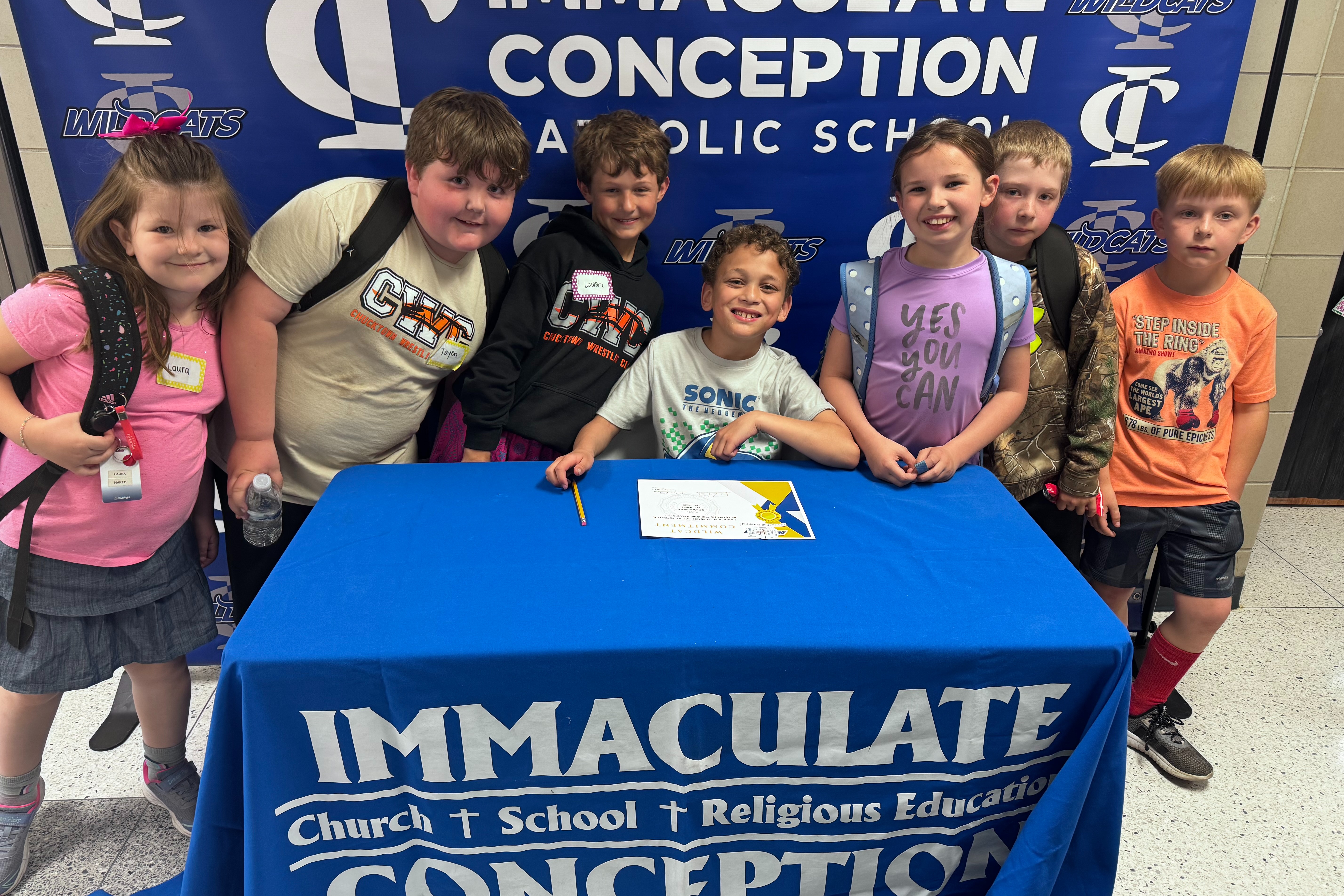 kids surrounding another students at a table