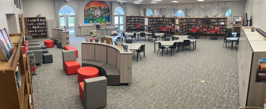 Interior of a library with wooden tables and chairs for studying.