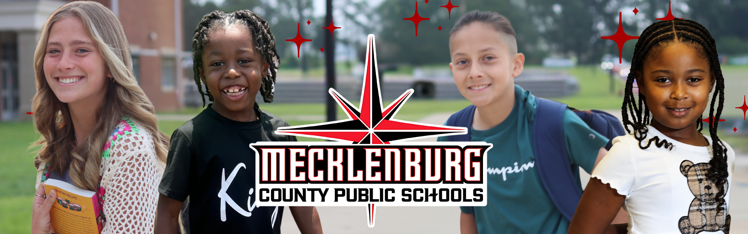 Four children stand outside a building with a Mecklenburg County Public Schools logo, set against a background of greenery and a road.