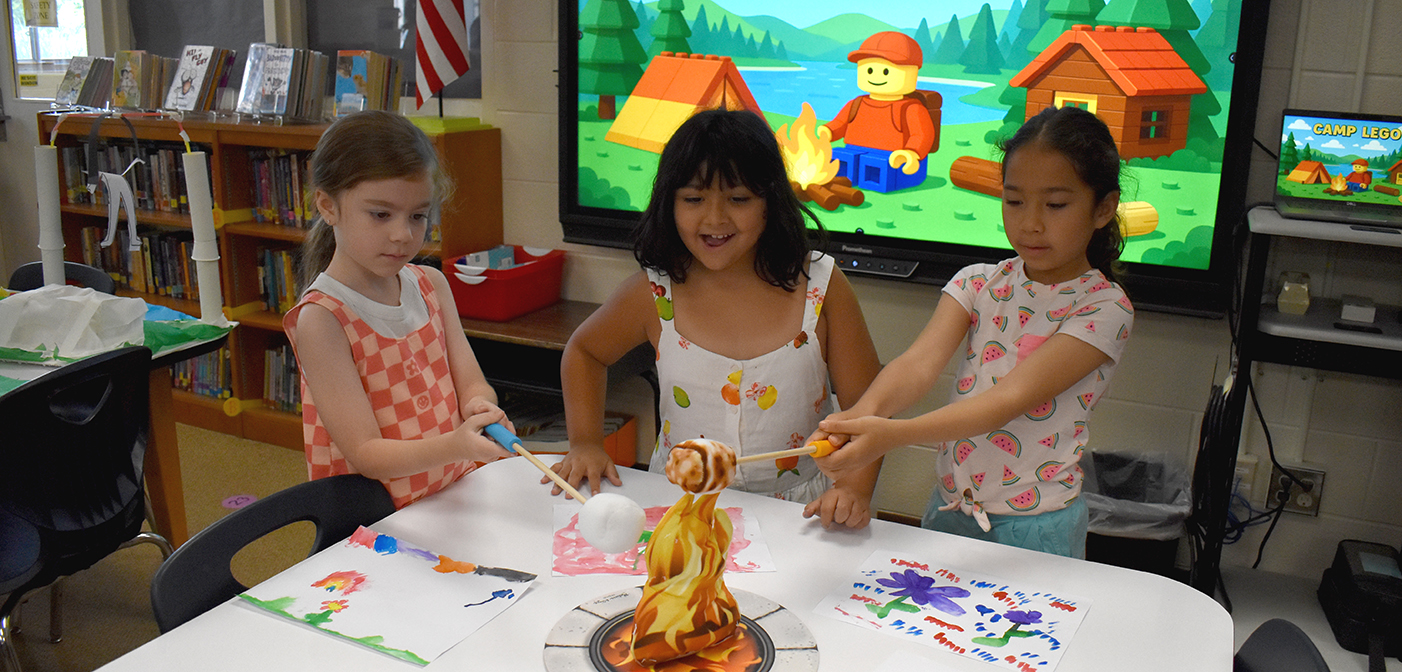 3 students roasting pretend marshmallows