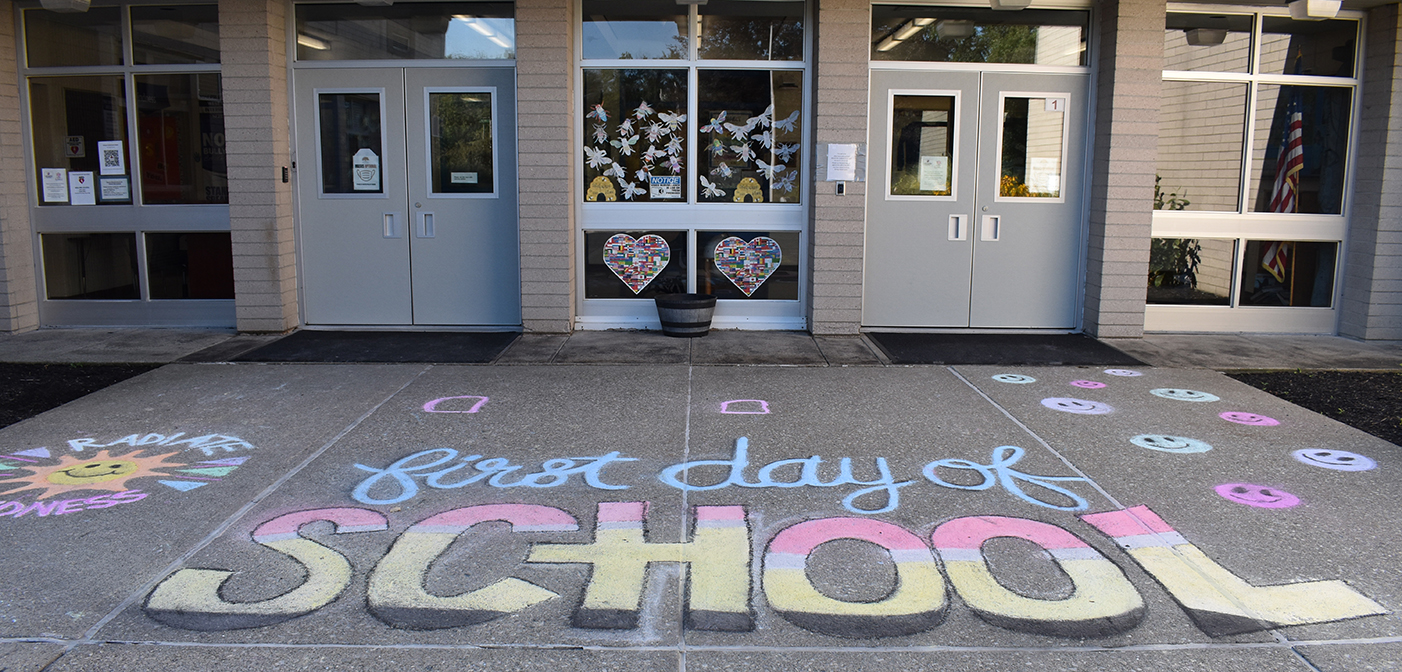 Chalk welcome message "first day of school" at West Rd