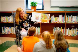 ILA Librarian reading books to students