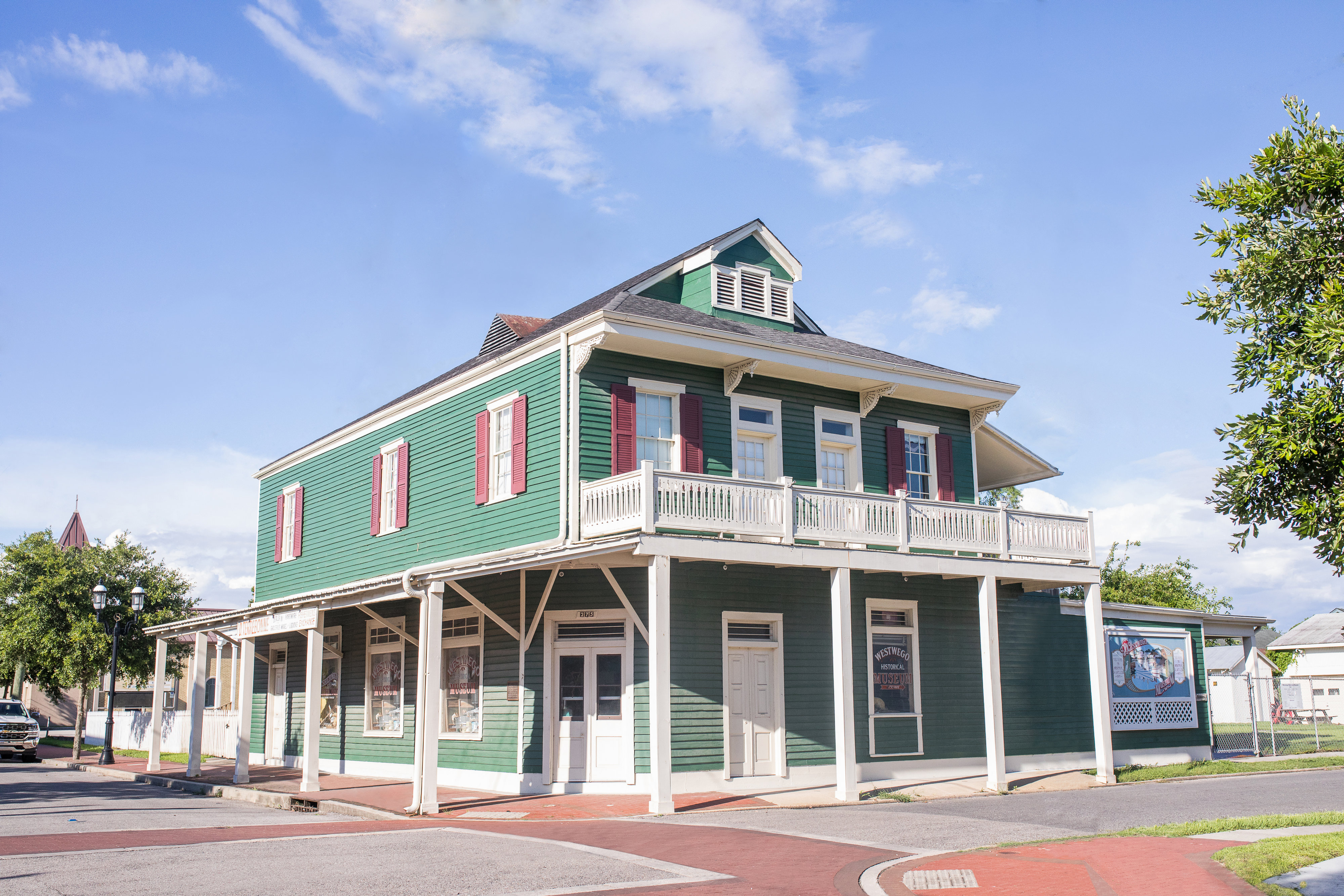 A green and white house with red shutters