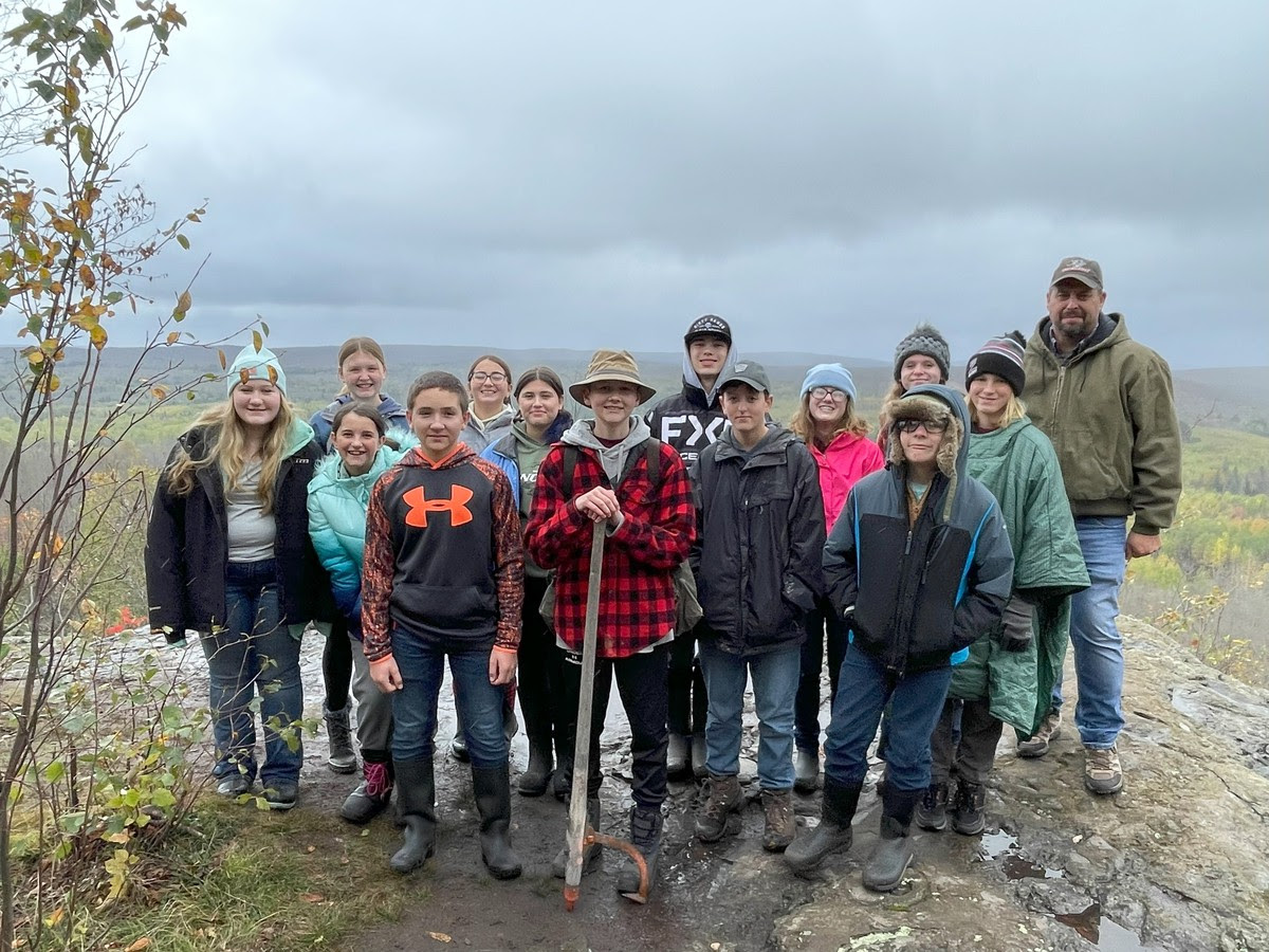 A group of people standing on a mountain top, enjoying the breathtaking view and feeling the sense of accomplishment.