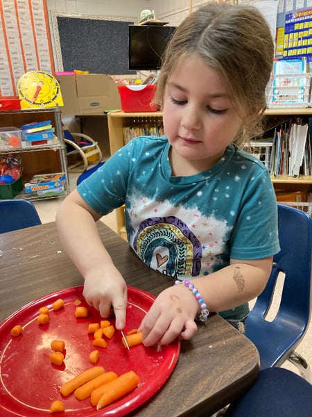 Child chopping on a table.