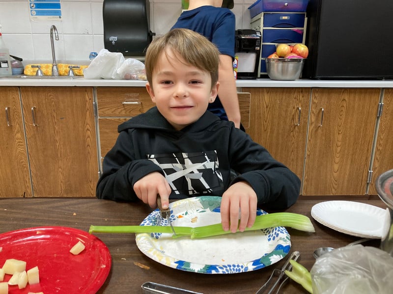 Child chopping on a table.