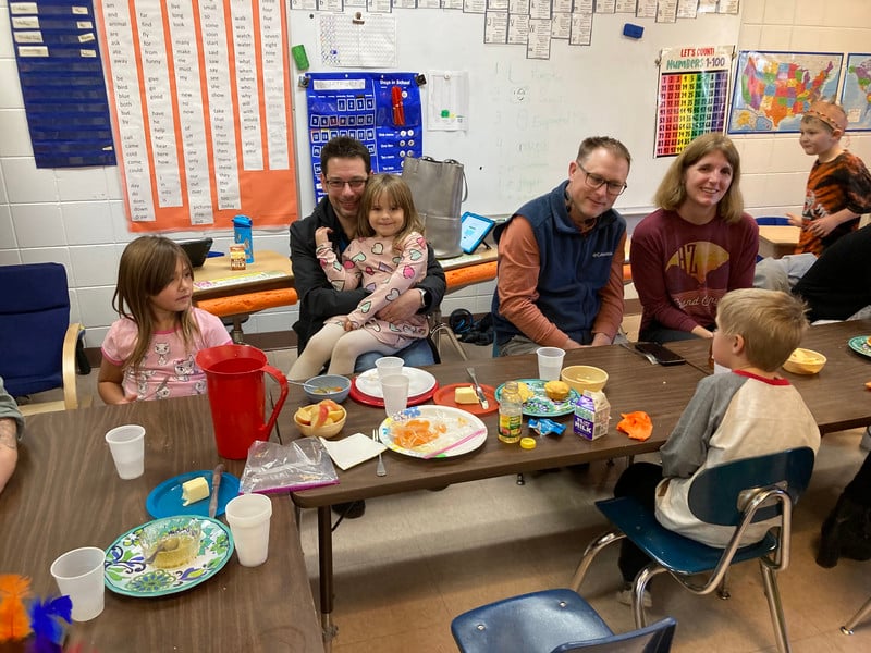 A diverse group of friends enjoying a meal together at a table, laughing and chatting.