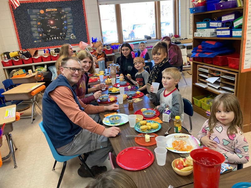 A diverse group of friends enjoying a meal together at a table, laughing and chatting.