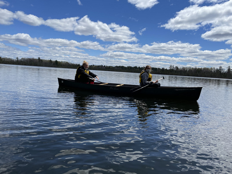 Two people in a canoe paddling on a lake