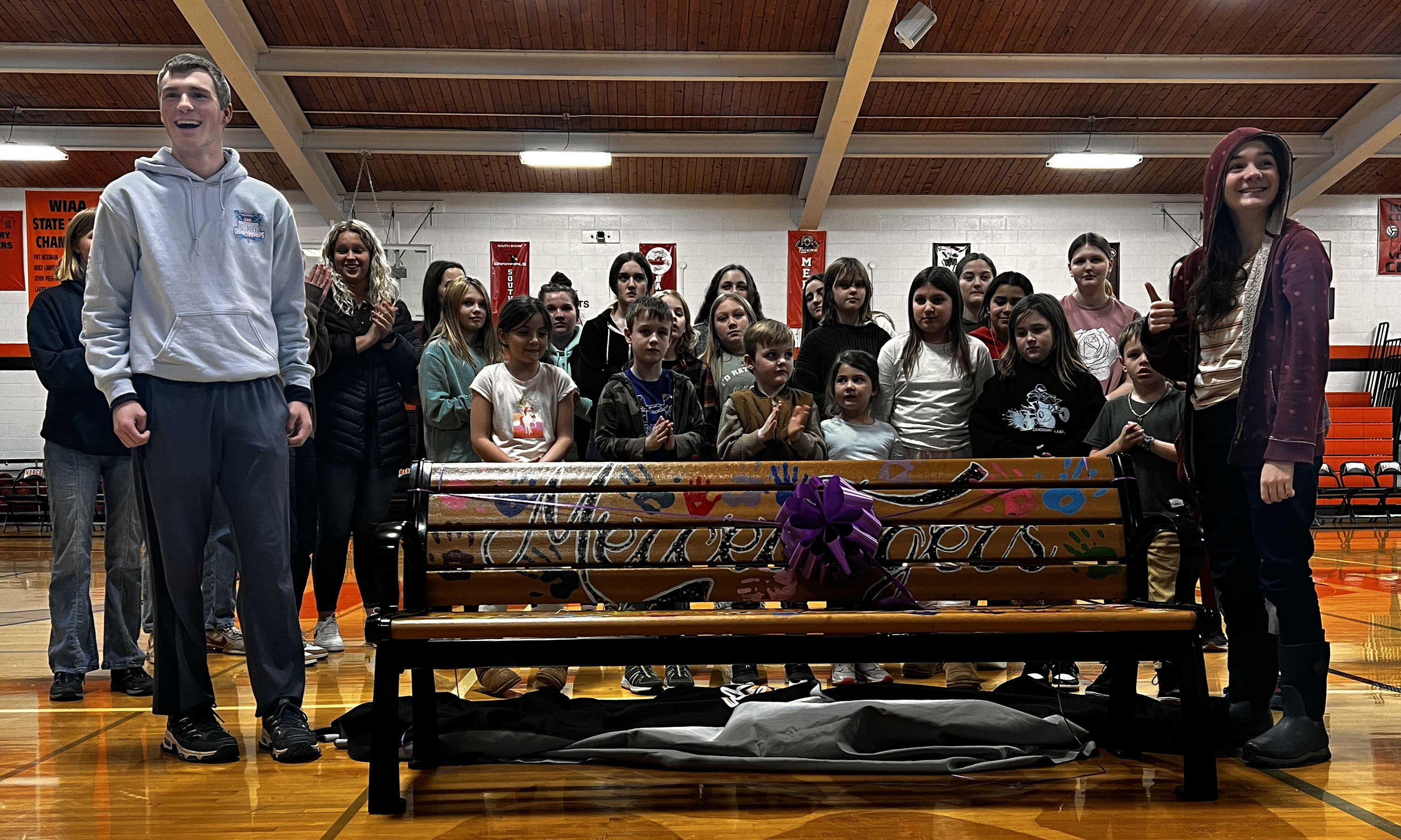 People of different backgrounds gathered around a bench.