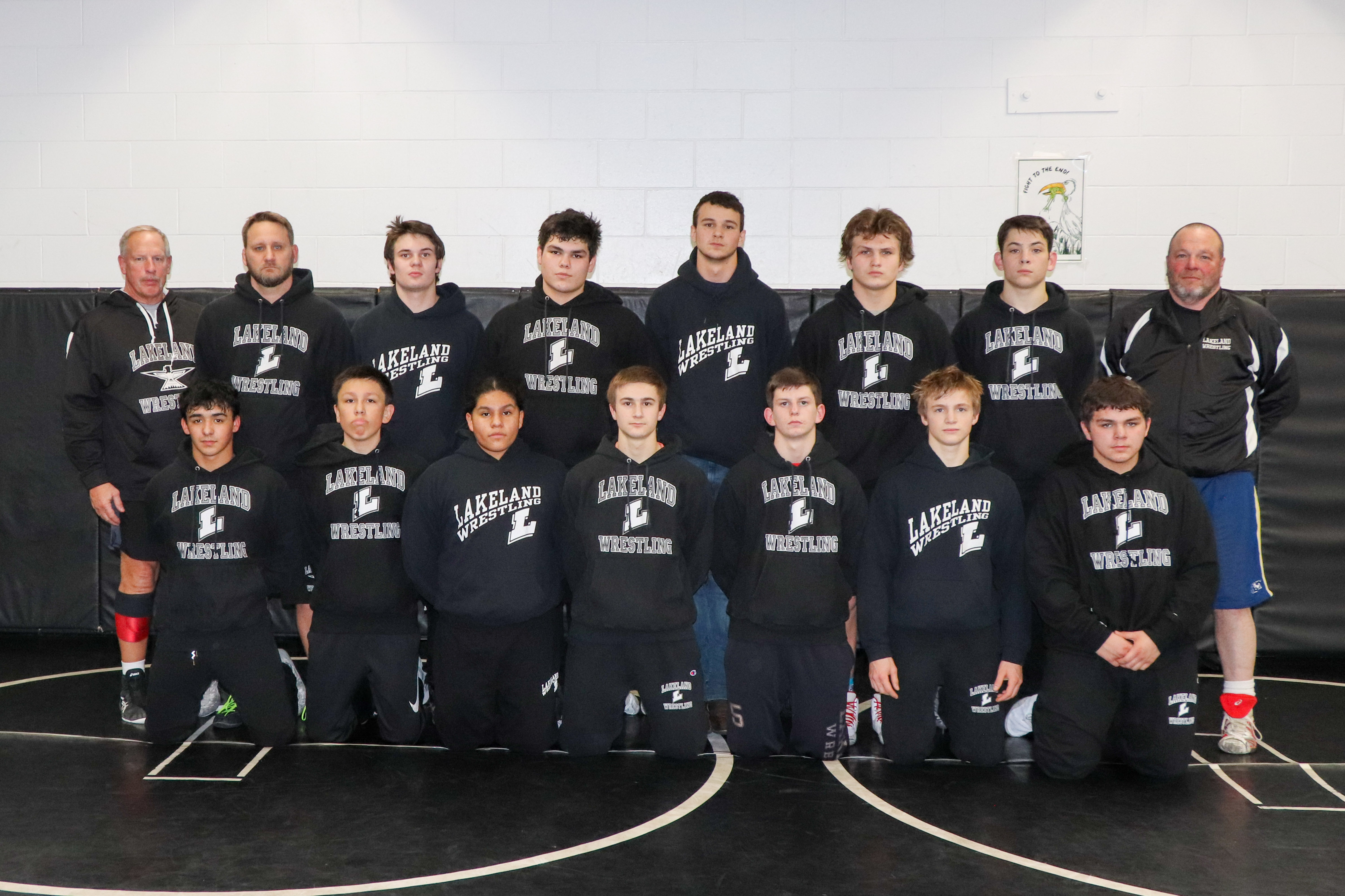 Wrestling team in gym, posing for photo.