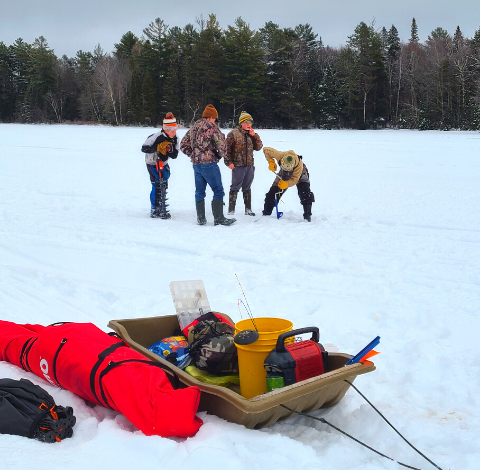 Several individuals standing together in a snowy landscape.