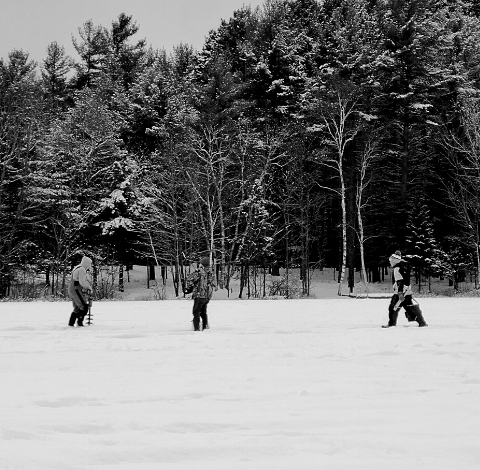 A monochrome image of individuals enjoying outdoor activities in the snow.