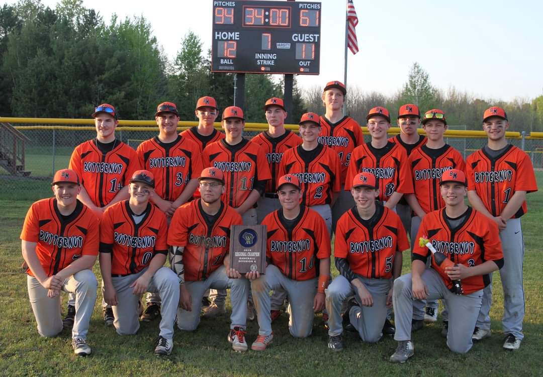 The baseball team proudly poses for a photo, celebrating their victory with the trophy in hand.