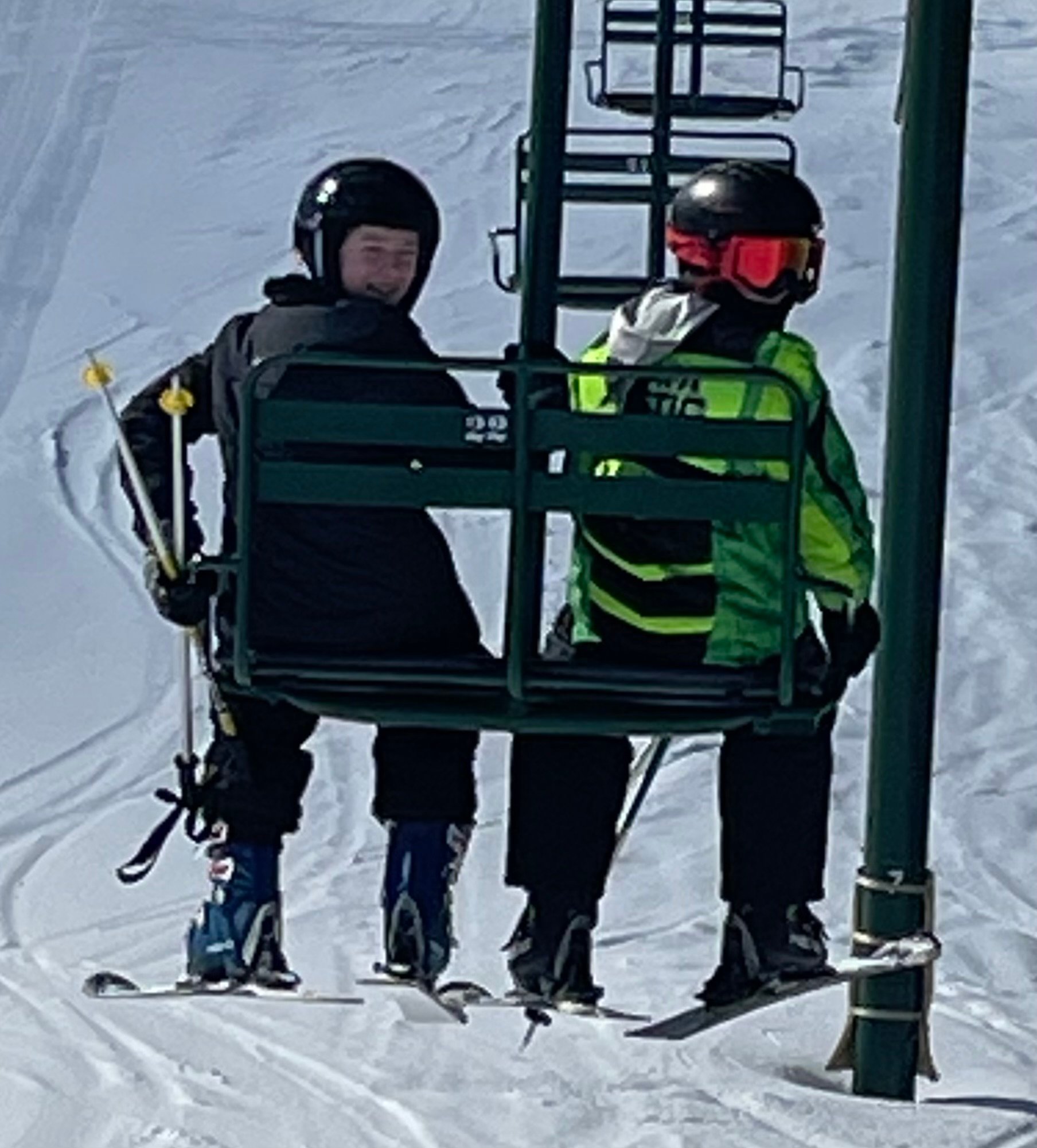 Two friends enjoying a ski lift ride