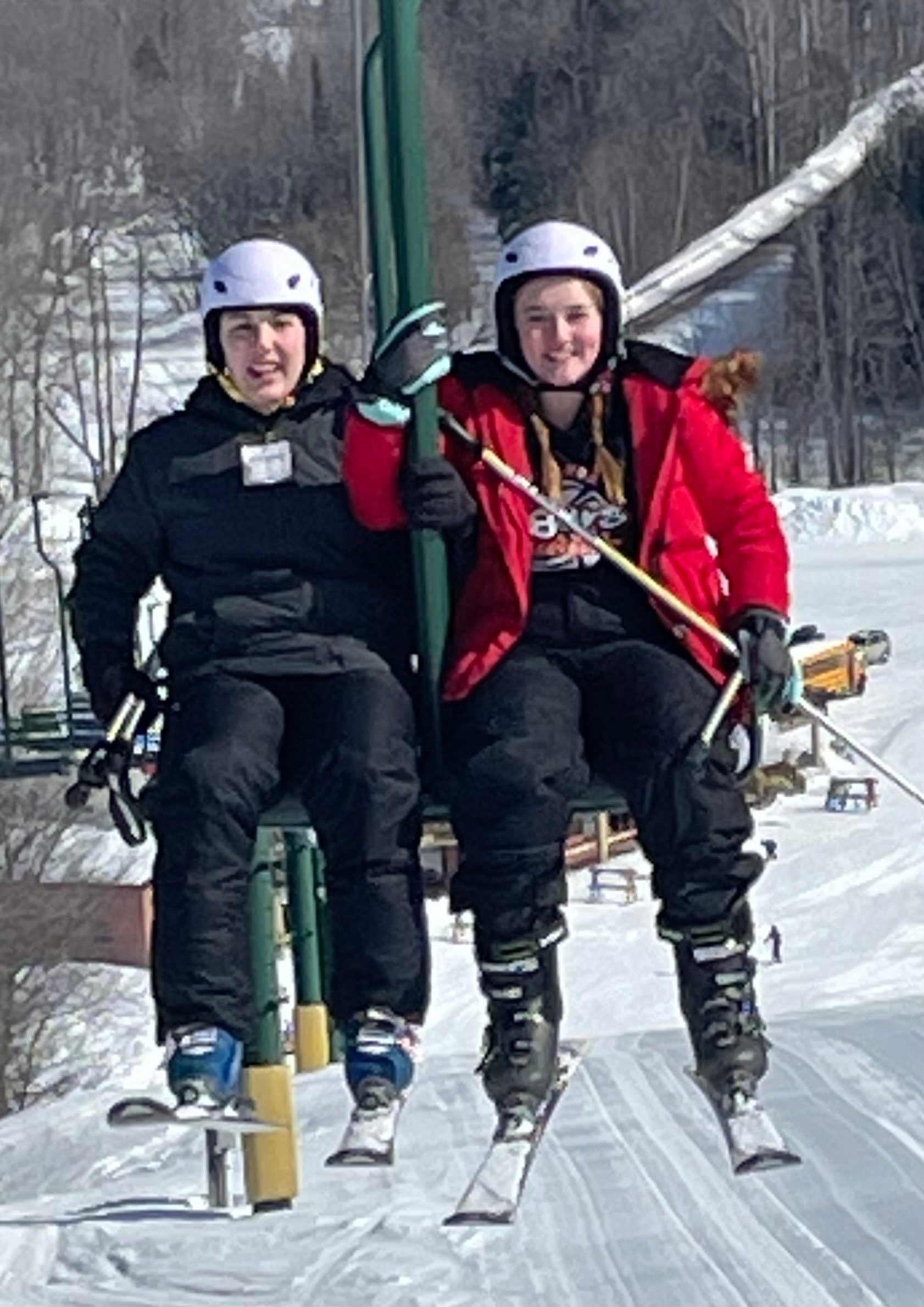 Two friends enjoying a ski lift ride