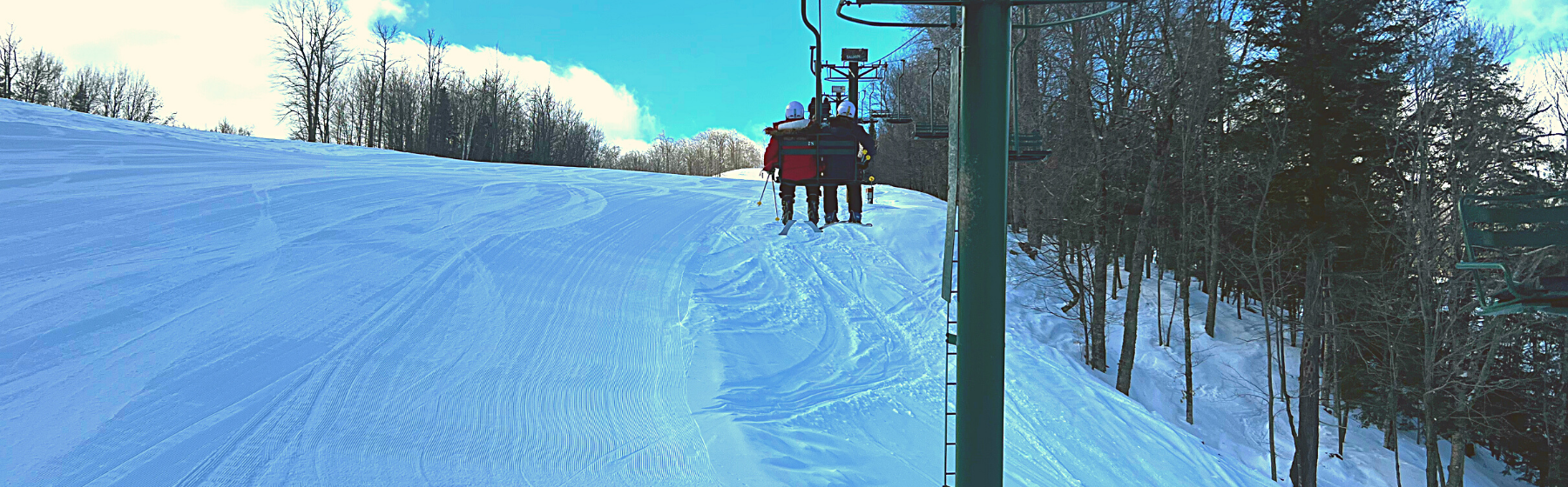 Two friends enjoying a ski lift ride