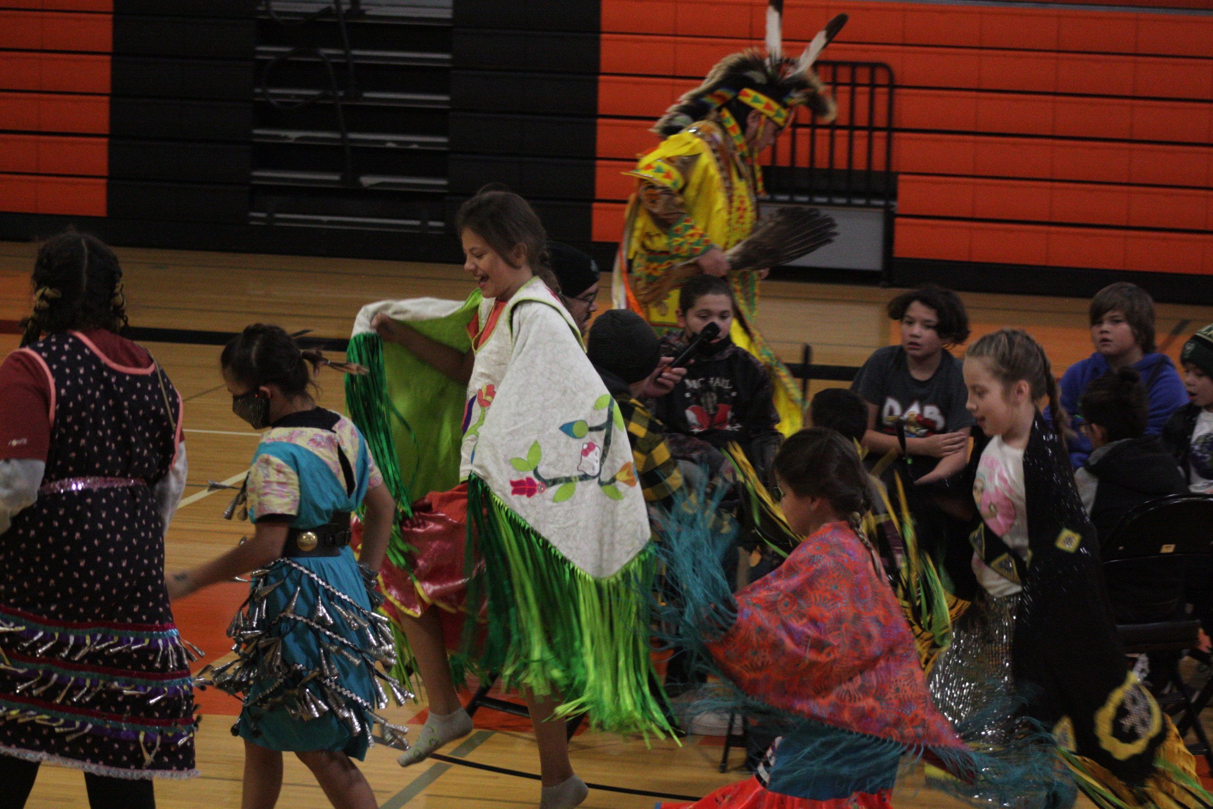 A group of young people dancing on top of a basketball court