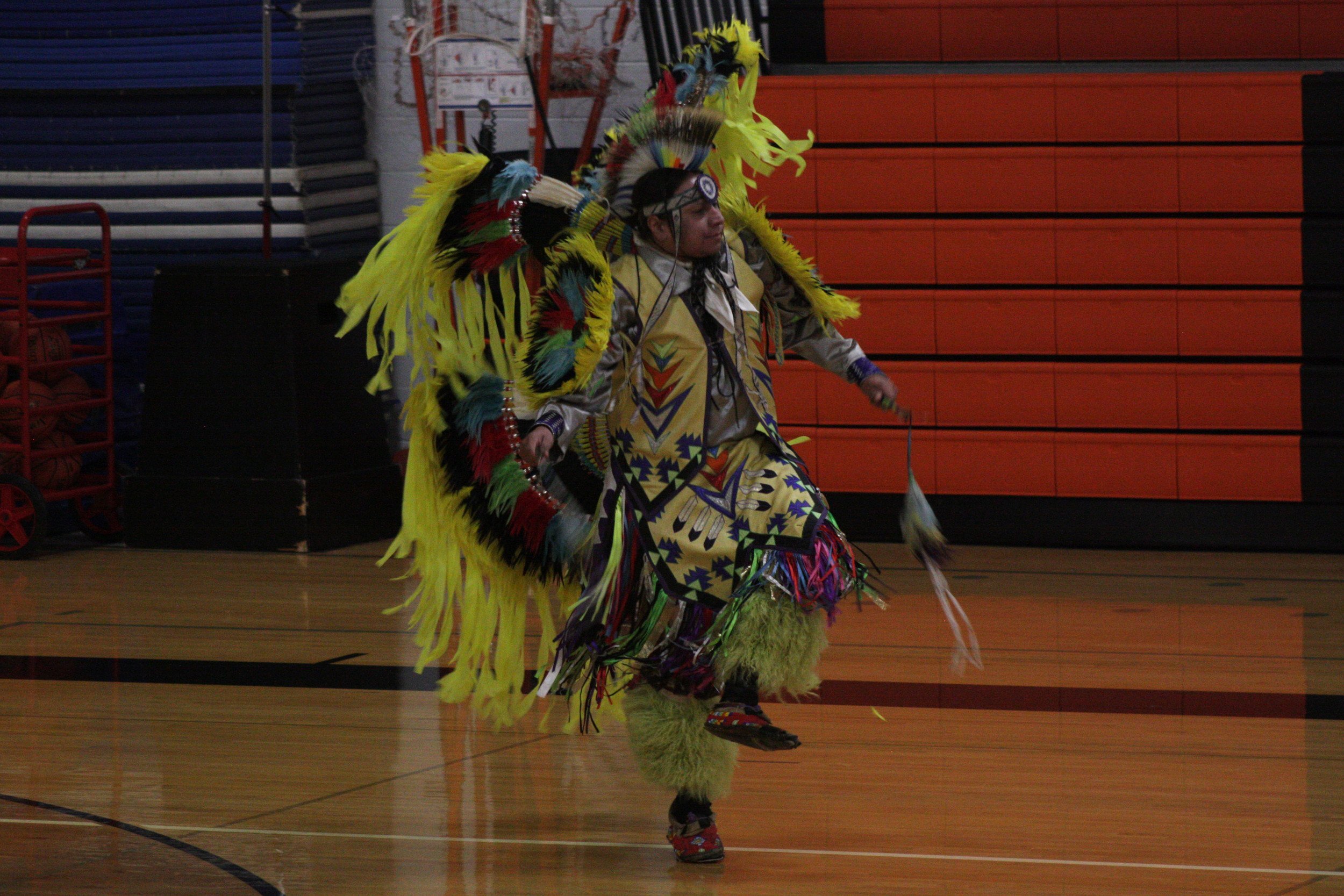 A man in a costume walking on a basketball court