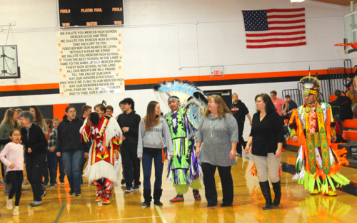 A group of people wearing Native American costumes at a cultural event.