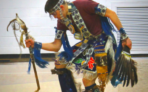 A man in Indian attire dancing on a basketball court.