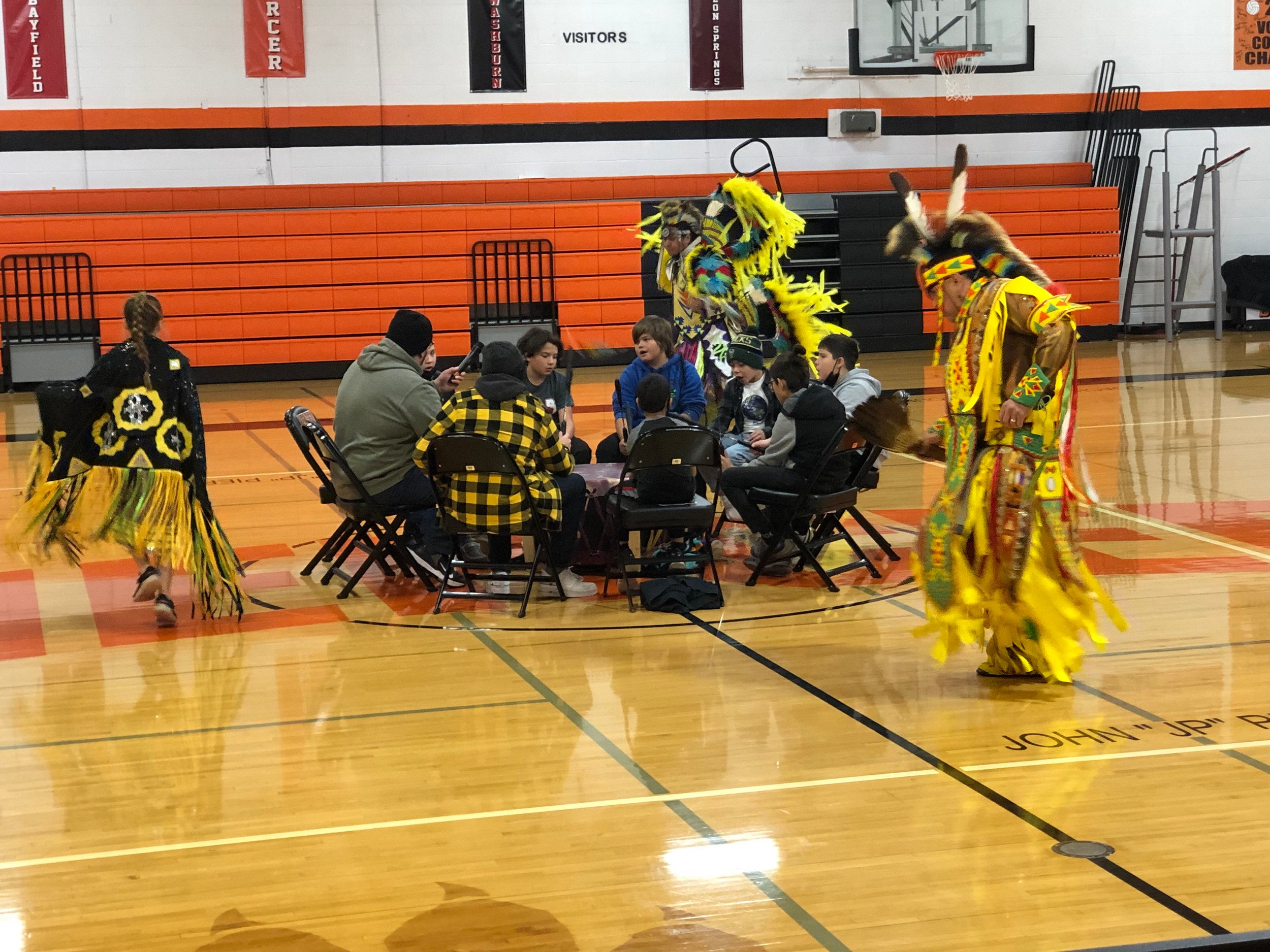 Group of people in Native American costumes at cultural event.