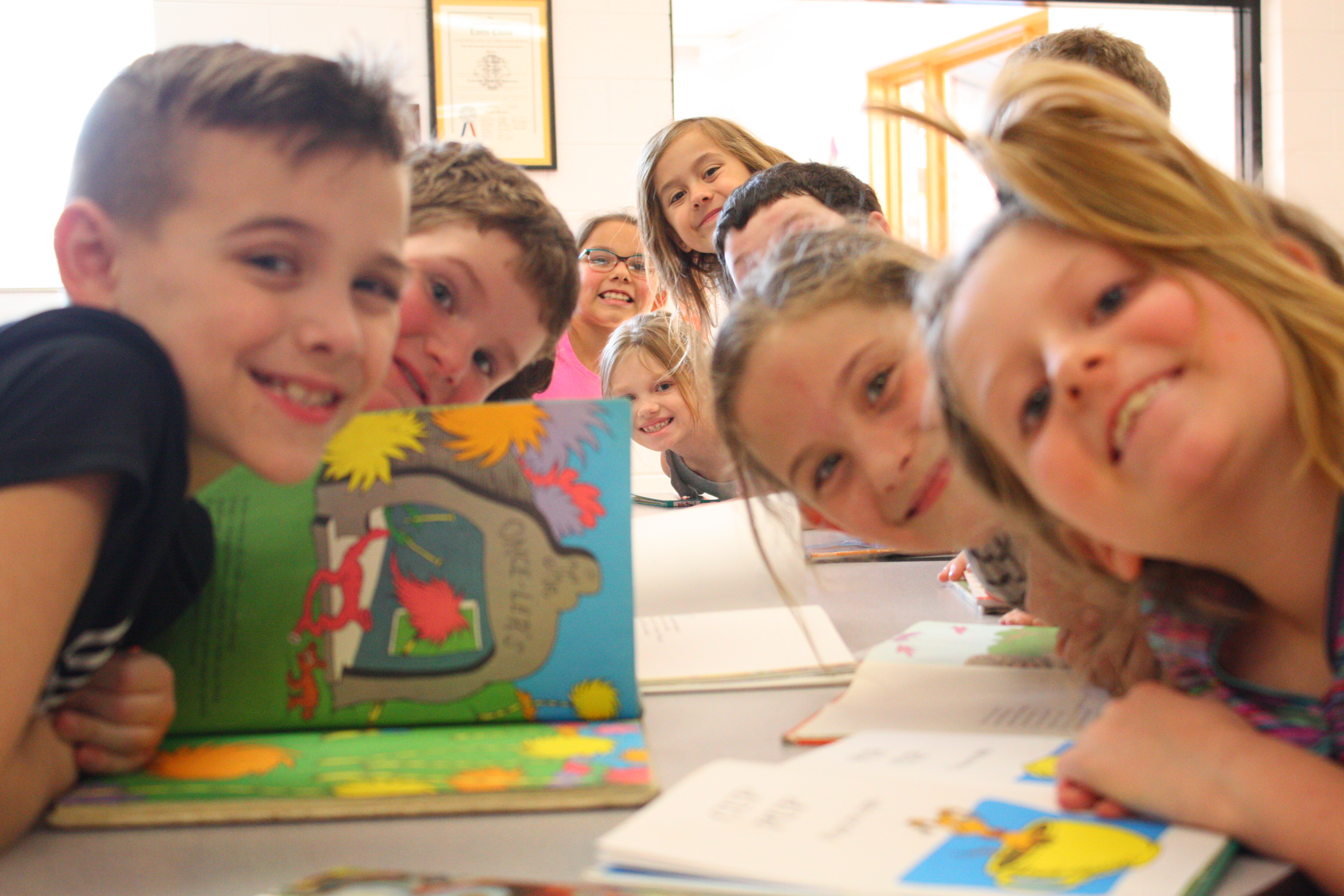 Children sitting at table with books