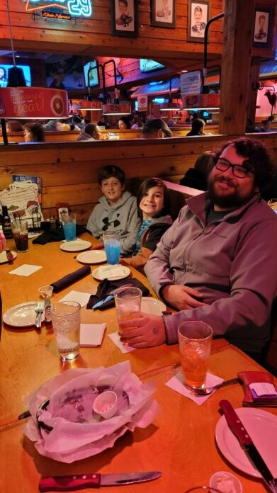 Happy family dining together at a restaurant table, sharing a meal and conversation.