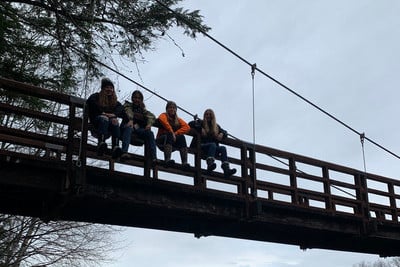 A group of people sitting on a bridge