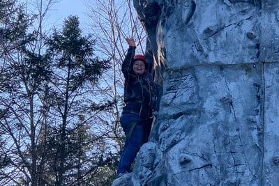 A man climbing up the side of a mountain