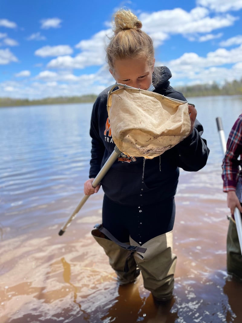 A girl holding a net in the water