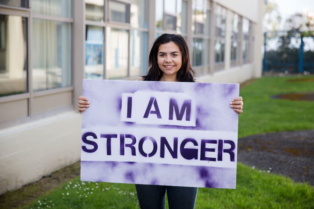 Student holding a poster saying Im stronger