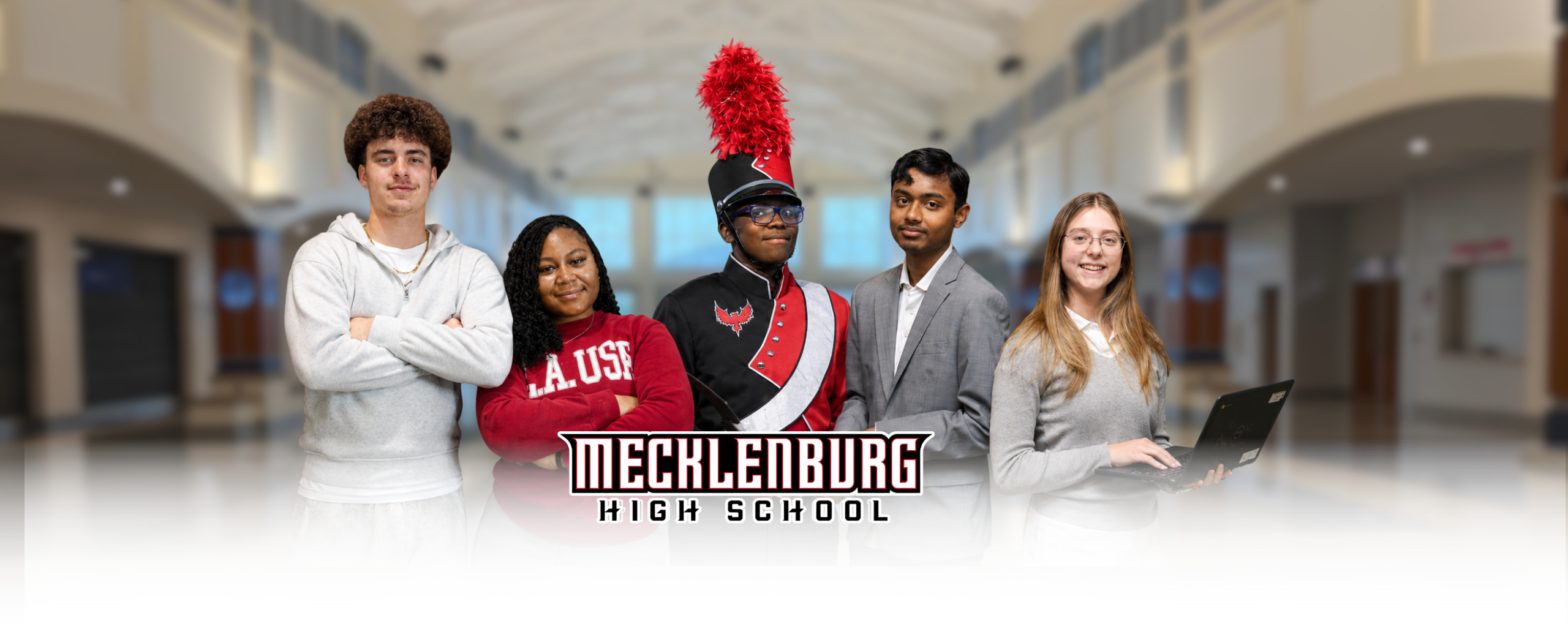 Five students stand in a school hallway with "Mecheleburg High School" written above them. They are smiling for the camera.