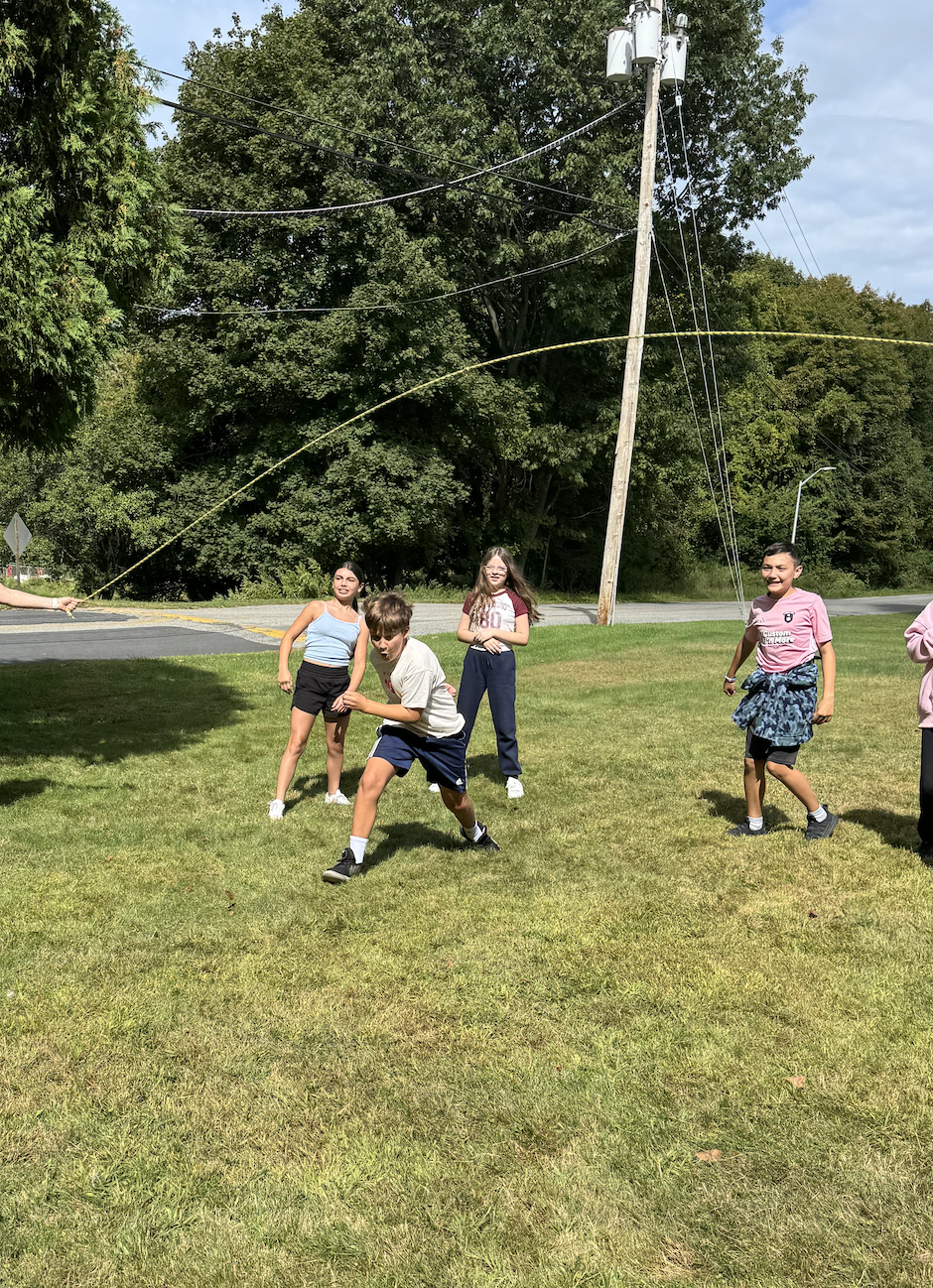 Pictures of students working together in the woods on obstacles
