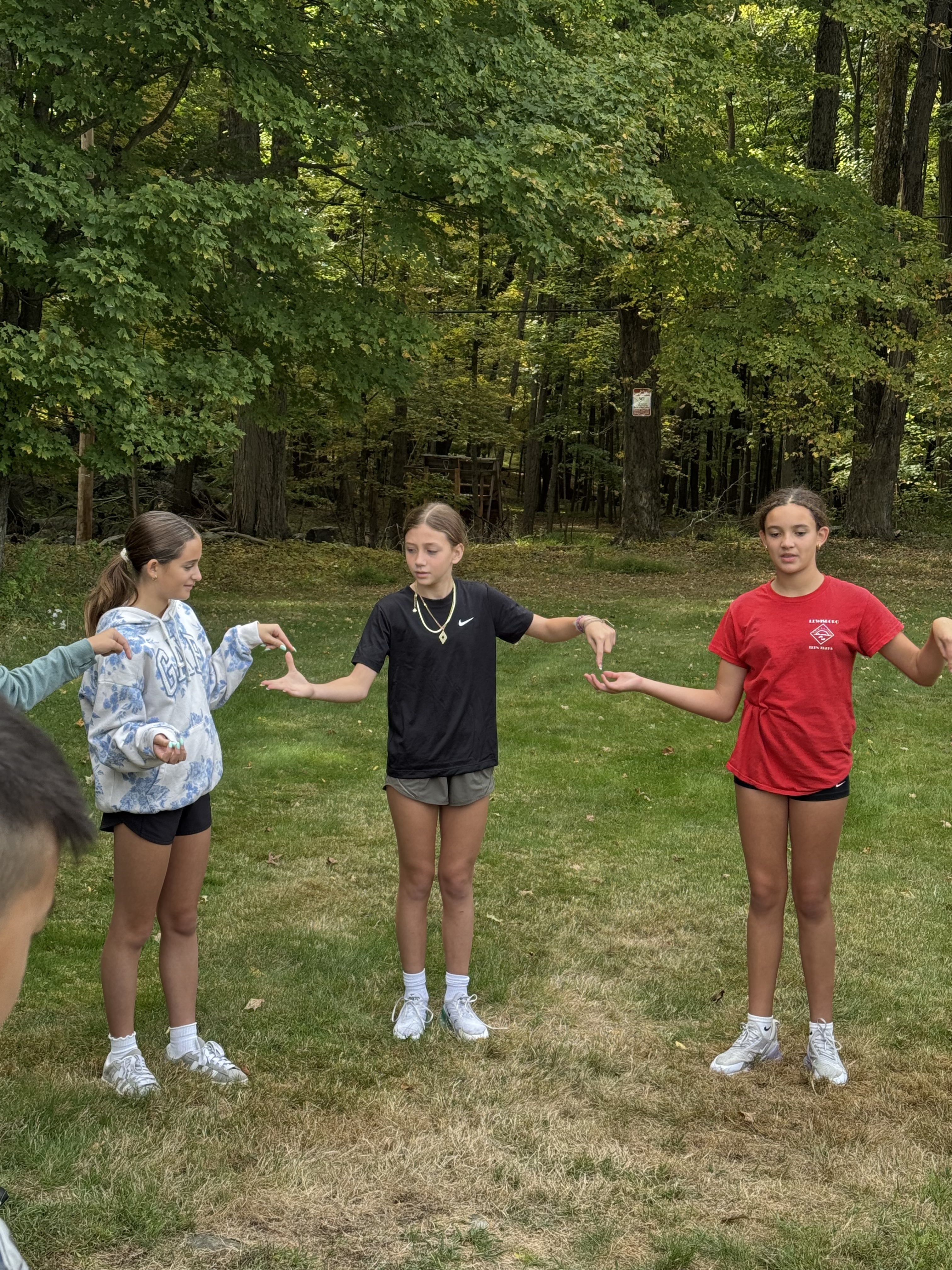 Pictures of students working together in the woods on obstacles