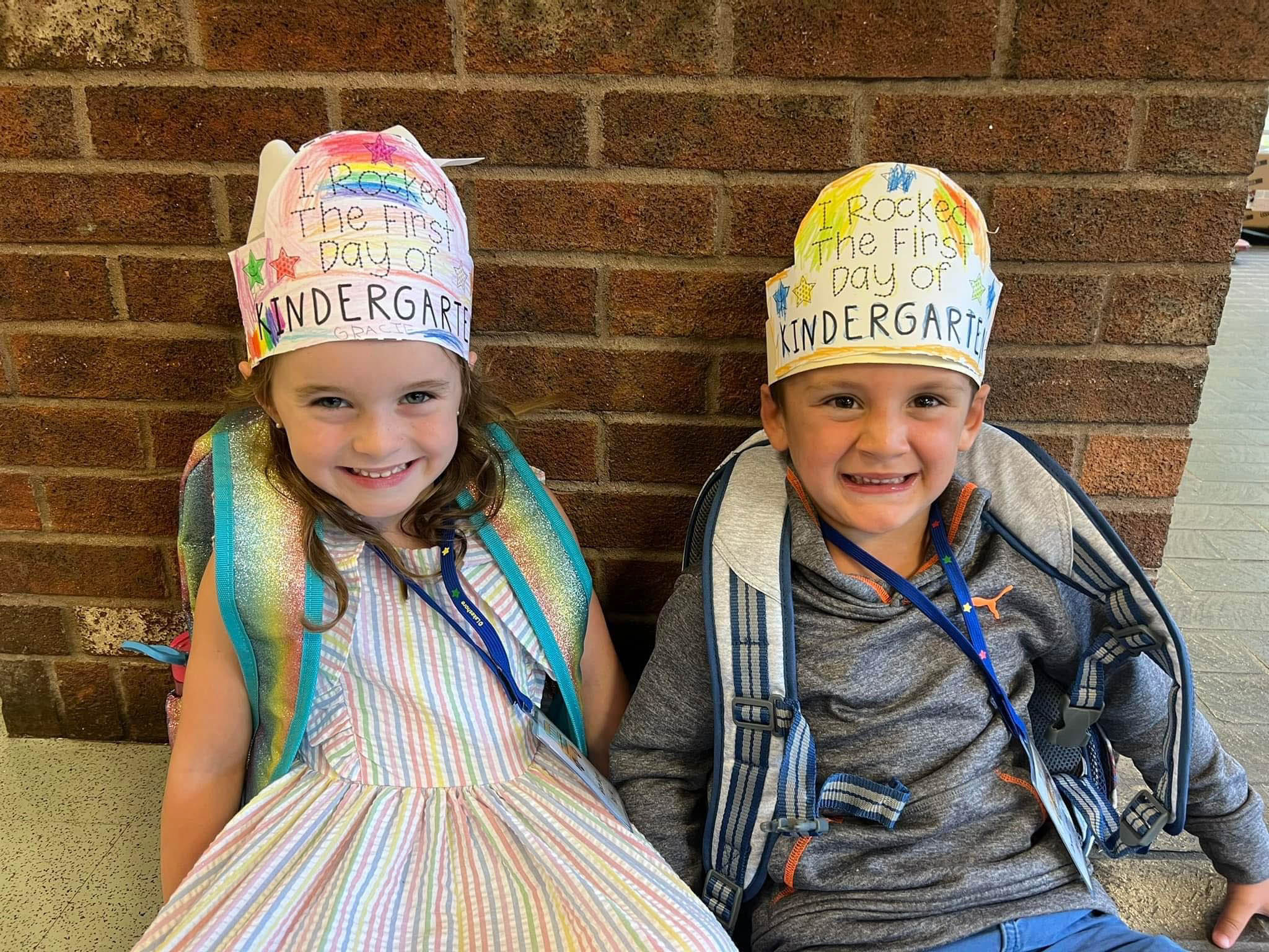 2 kindergarten kids wearing we rocked our first day of kindergarten hats.