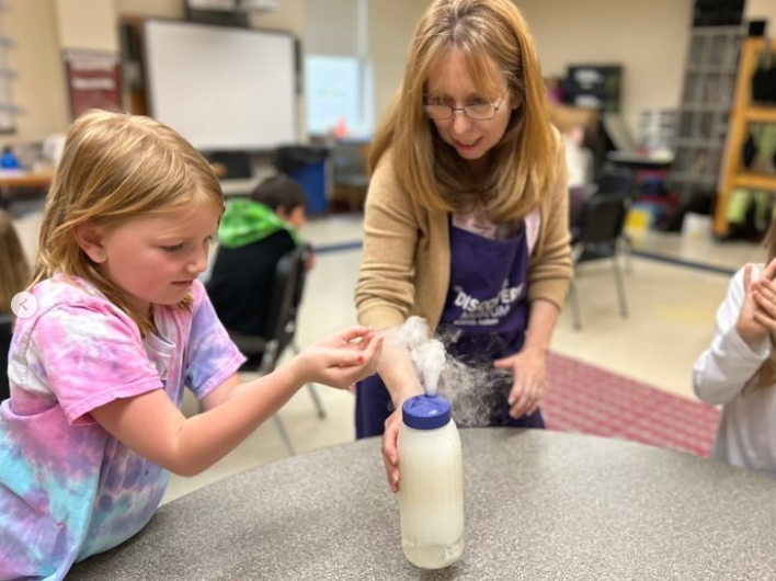 student doing an experiment with teacher