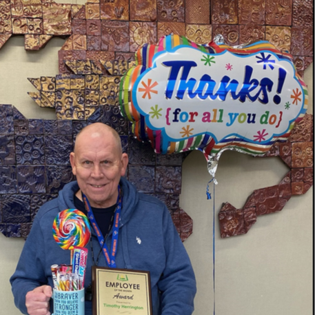 Mr. Keith Herrington holding an Employee of the Month Award