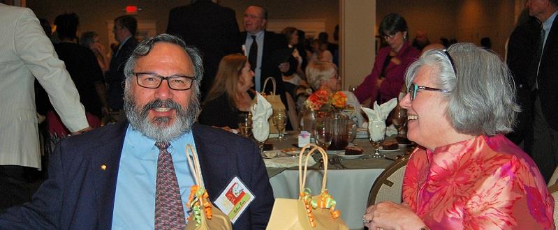 Two retired employees cheerfully attending a banquet.