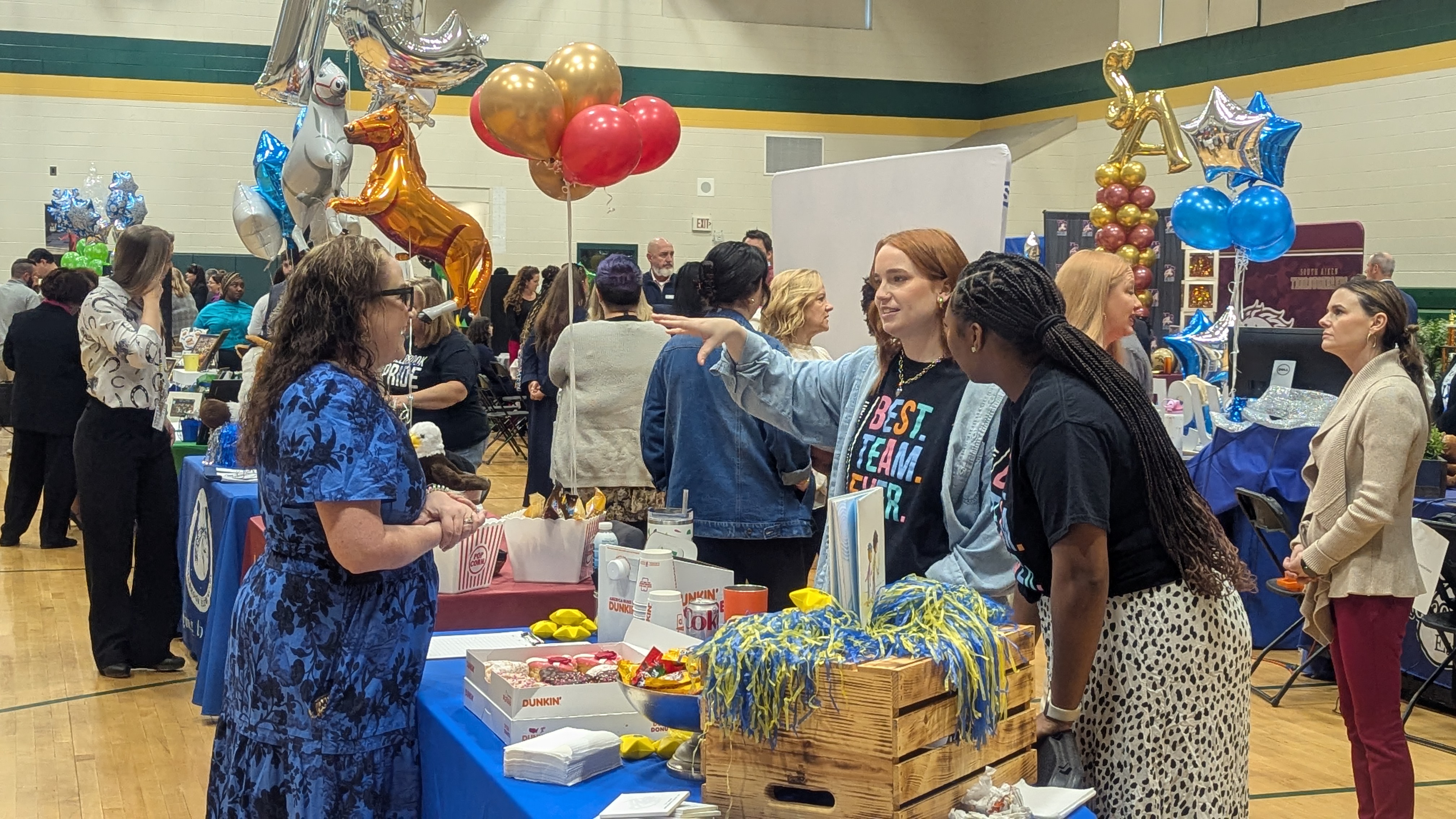 Adults speaking at a school district hiring event. 