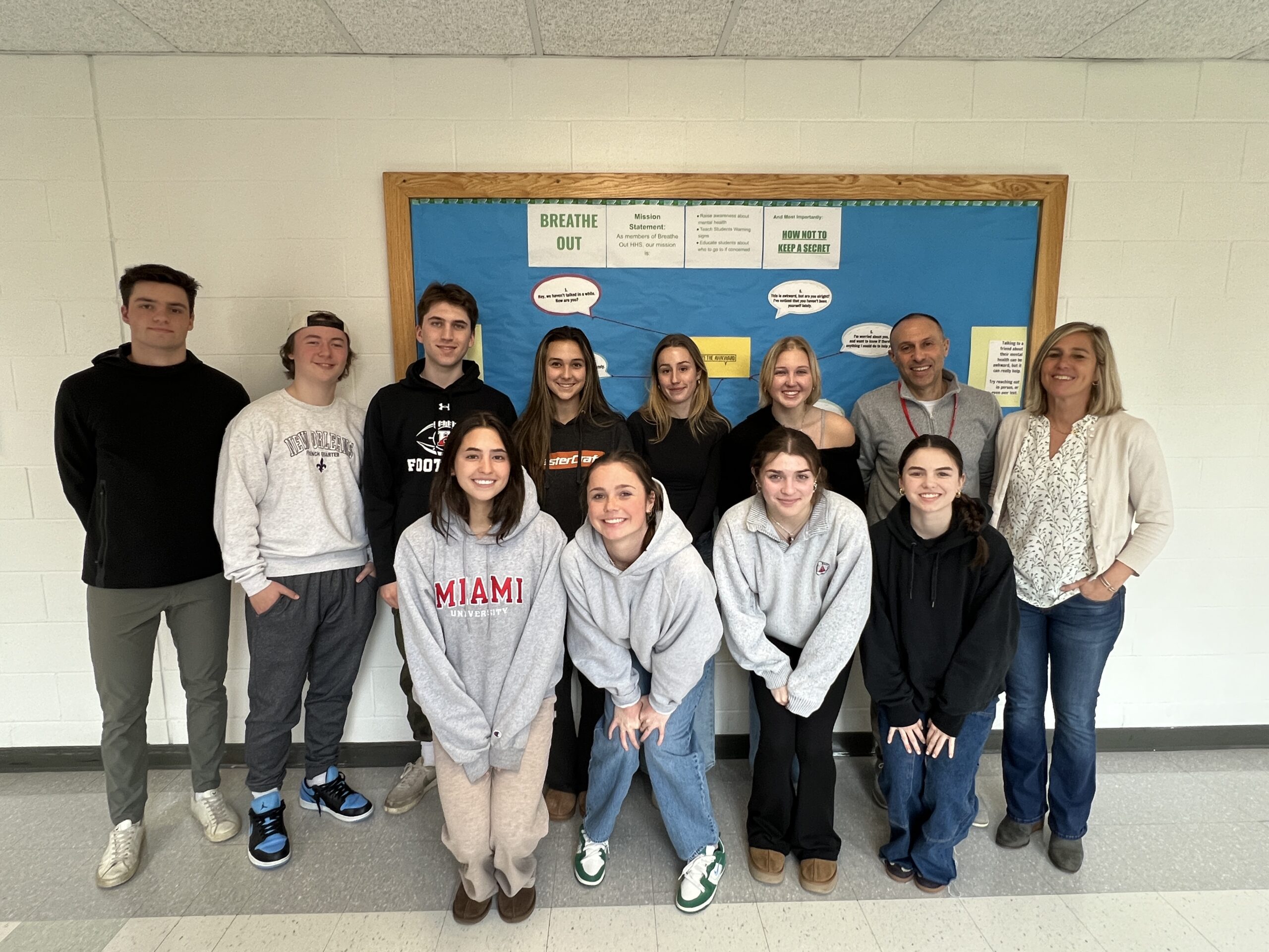 A group of people standing in front of a bulletin board