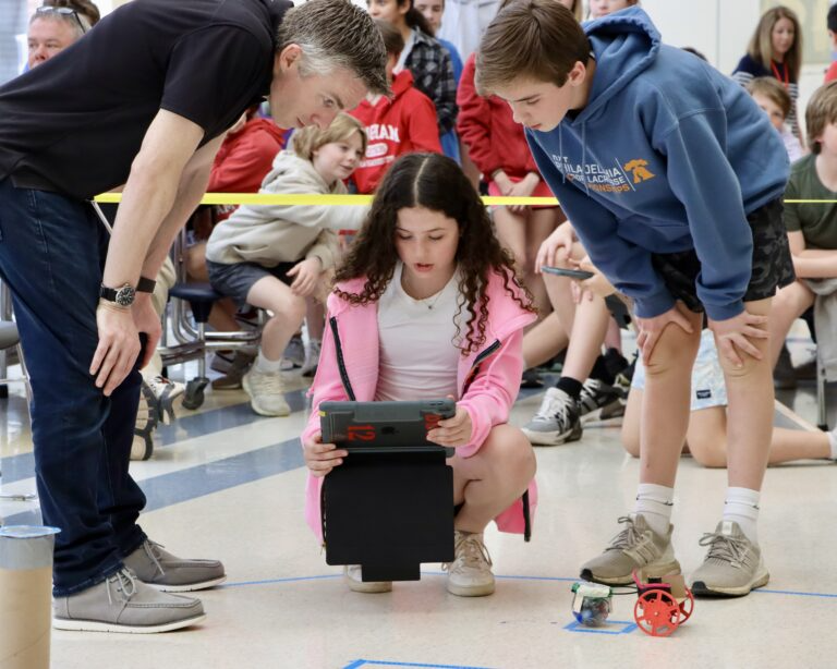 Children happily playing with a robot toy.