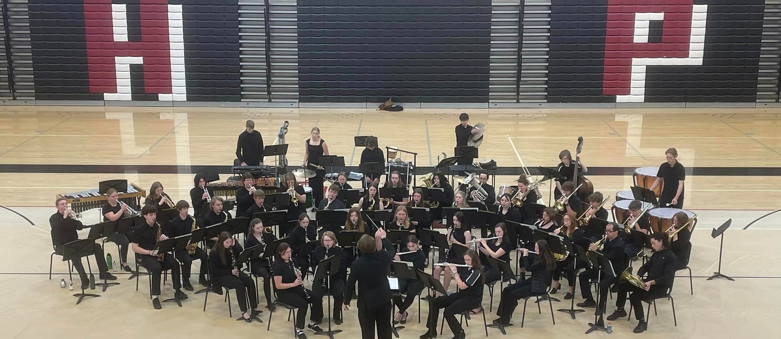 students in the band all together seated in a concert playing intruments