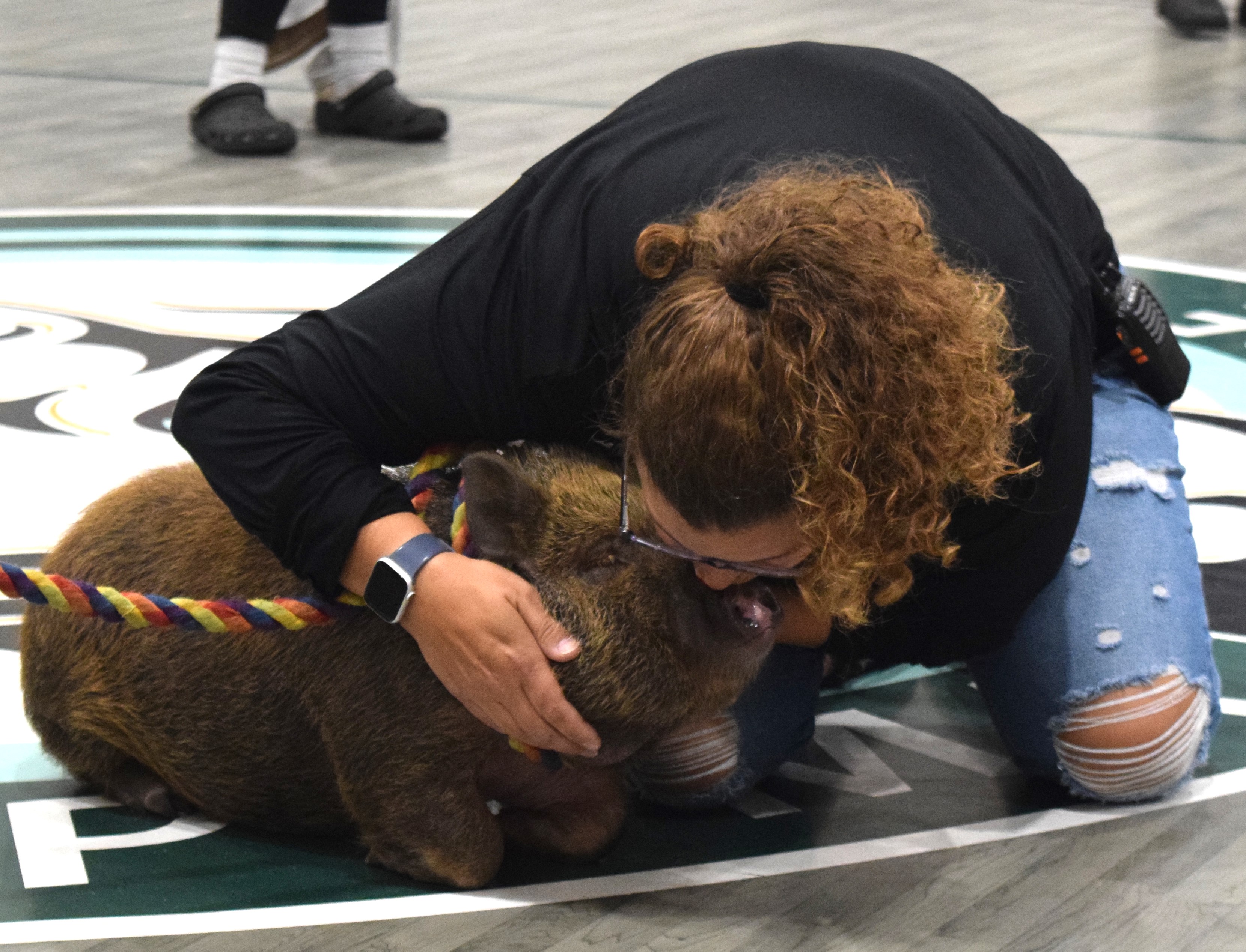 Mrs. Bovee kisses the pig for the Dig-Pink fundraiser