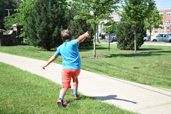 A young boy is in the middle of an action shot while playing in a park.