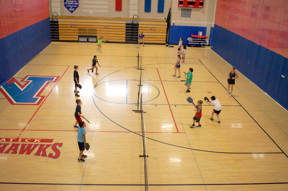 People playing basketball indoors.