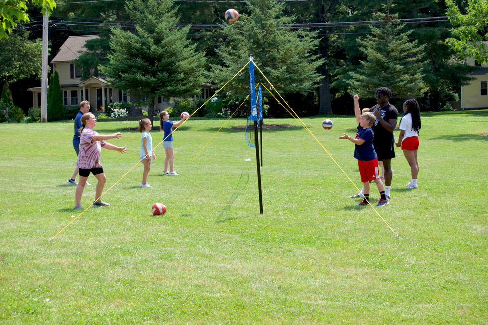 People enjoying an outdoor game of volleyball.